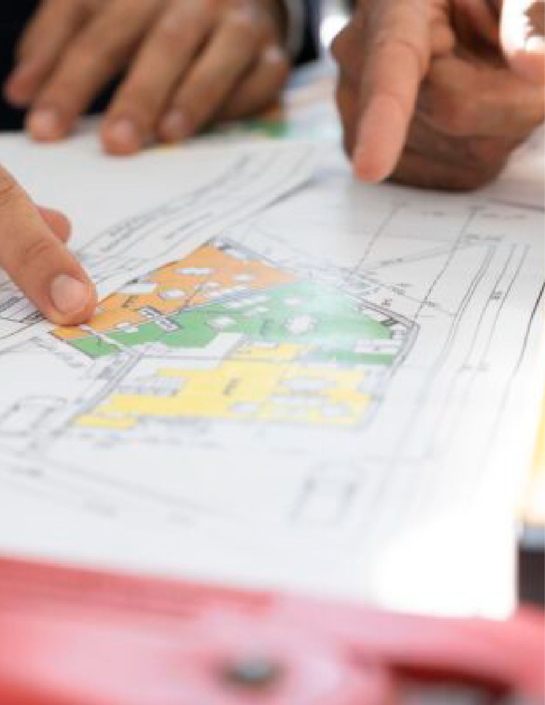 Photographie de deux personnes examinants un plan de construction d'une maison